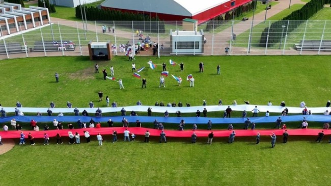Birleşik Rusya eylemcileri en uzun üç renkli kurdeleyi uzatmak için Moskova’da bir flaş kalabalık düzenlediler